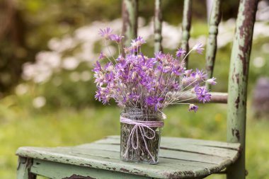 ahşap sandalye üzerinde bir kavanoza güzel pembe çiçekler Buket