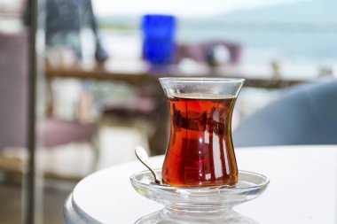 Turkish tea with authentic glass cup and decorative vase with flowers