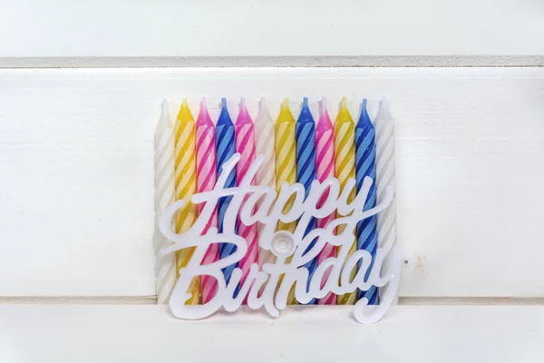 birthday candles and happy birthday sign isolated on a wooden background