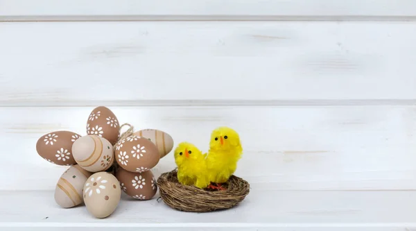 イースターエッグと白い木製の背景に黄色の鶏 — ストック写真