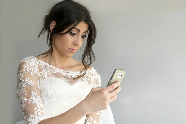 Novia Vestido Blanco Con Pelo Morena Usando Smartphone —  Fotos de Stock
