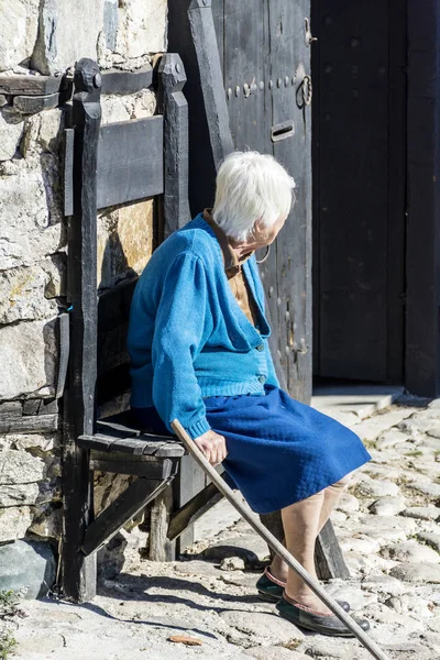 都会の通りでベンチに座っている灰色の髪の高齢女性 — ストック写真