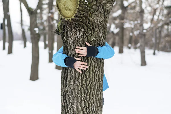 woman  hugging a tree in a winter park