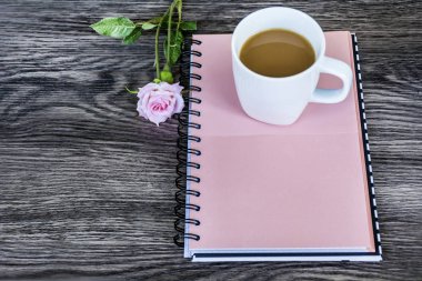 Defter, pembe gül ve kahve. Bahar sabah kavramı 