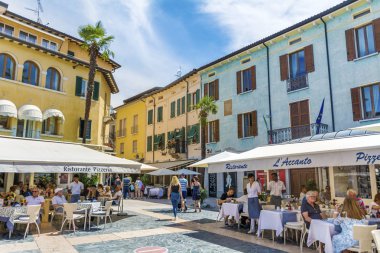 SIRMIONE,ITALY -JUNE 27,2018:  Italian Restaurant with White Umbrellas Full with People in Italy 