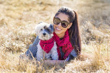 Güzel gülümseyen kadın onu sevimli Havanese köpek kırmızı eşarp ile sarılma. Moda için sahip ve köpek .