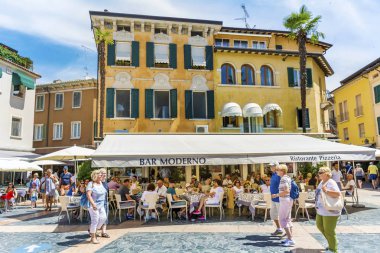 SIRMIONE,ITALY -JUNE 27,2018:  Italian Restaurant with White Umbrellas Full with People in Italy 