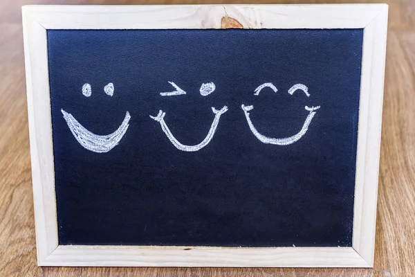 Different Smiles Painted on a Black Chalk Board