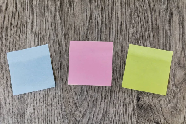 Colorful Sticky Notes Pasted on a Wooden Background