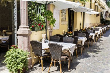 Como, İtalya, 27 Haziran 2018: Cozy İtalyan restorantı ile Beyaz şemsiye ve tablolar üst üste İtalya sokakta