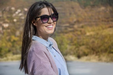 Güzel gülümseyen bir merdivenlerde oturan siyah gözlüklü genç kadın 