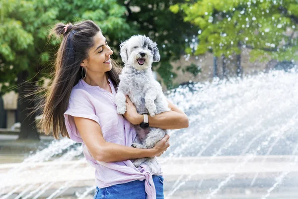Güzel gülümseyen kadın onu sevimli Havanese köpek sarılma. Evde beslenen hayvan ve sahip açık