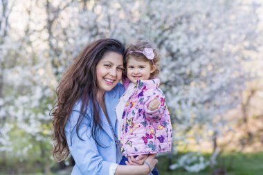 Bahar parkında çocuğu ile mutlu anne. Anne ve kızı. Küçük çocuk ile mutlu aile. Anne