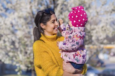 Güzel parkta küçük çocuğunu elleri tutan anne 