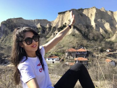 Gülümseyen güzel genç kadın dağ yakınında poz