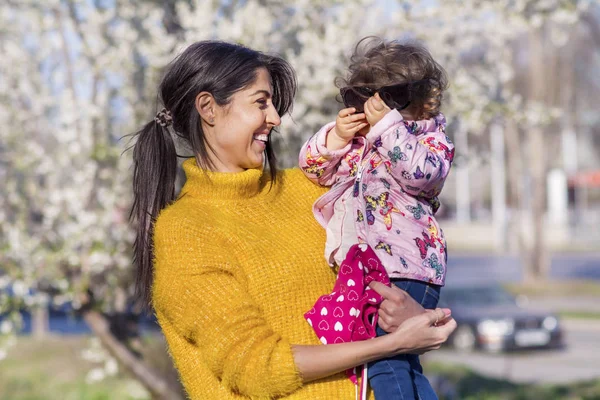 Güzel parkta küçük çocuğunu elleri tutan anne 