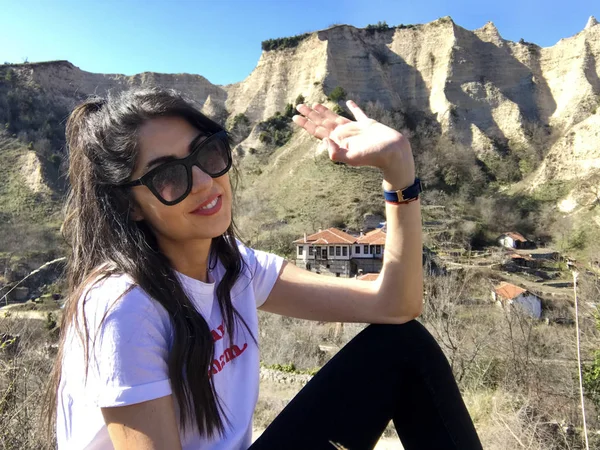 Gülümseyen güzel genç kadın dağ yakınında poz