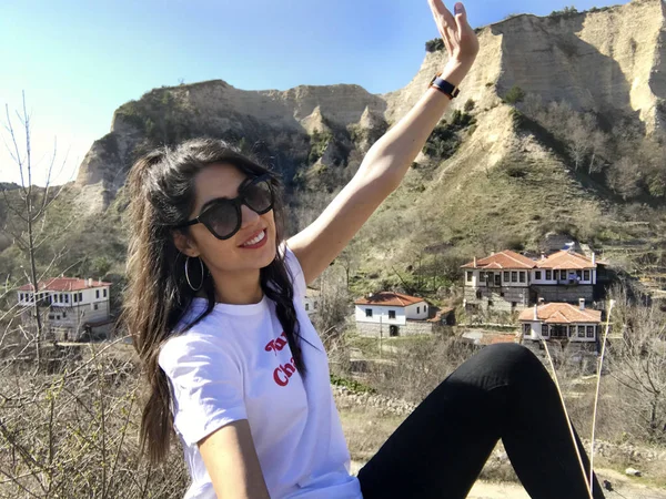 Gülümseyen güzel genç kadın dağ yakınında poz