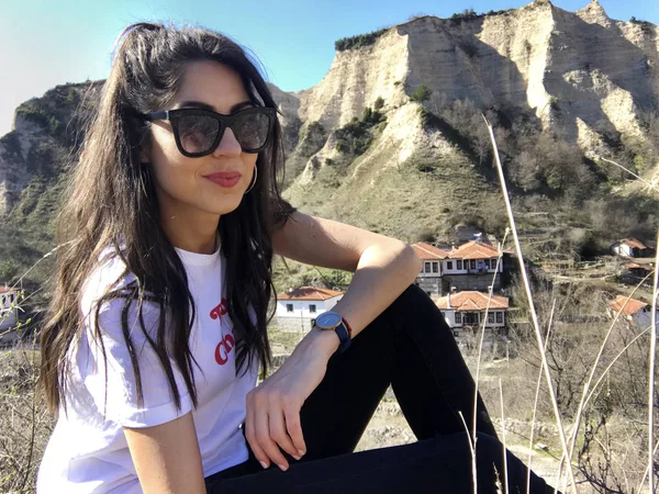 Gülümseyen güzel genç kadın dağ yakınında poz