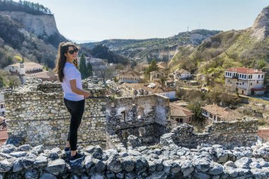 Eski taş kale üzerinde şık genç kadın 