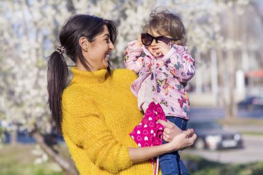 Güzel parkta küçük çocuğunu elleri tutan anne 