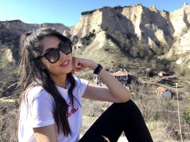 Dağın yakınında poz veren genç kadın