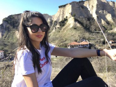 Dağın yakınında poz veren genç kadın