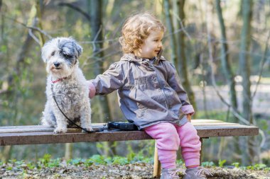 Parkta köpeğiyle küçük şirin bir kız.