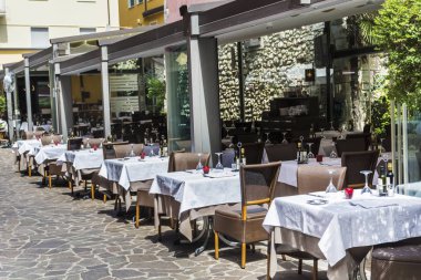 Como, İtalya, 27 Haziran 2018: Cozy İtalyan restorantı ile Beyaz şemsiye ve tablolar üst üste İtalya sokakta