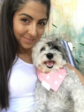 Güzel gülümseyen kadın onu sevimli Havanese köpek kırmızı eşarp ile sarılma. Moda için sahip ve köpek .