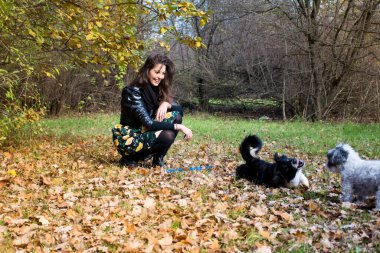 Güz Parkı 'nda Köpekleriyle Oynayan Güzel Gülümseyen Kadın ve Doğanın Mutlu Sahibi