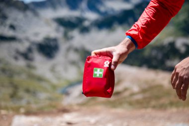 Man holding first aid kit in the mountain