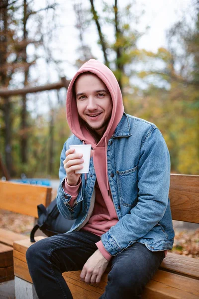 Fashion caucasian man drinking cappuccino outside.
