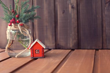 Noel ağacı oyuncak kırmızı ev ve Noel ağacı dalları ile ahşap bir adam bir banka kış meyveleri