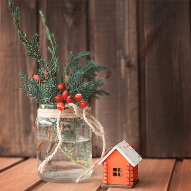 Noel ağacı oyuncak kırmızı ev ve Noel ağacı dalları ile ahşap bir adam bir banka kış meyveleri