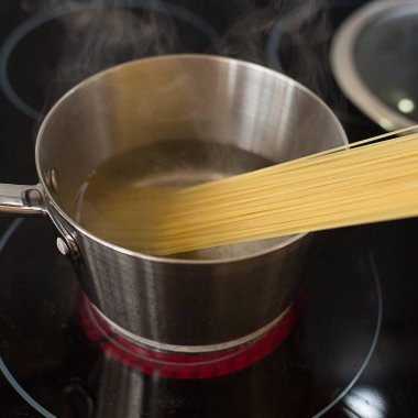 spagetti makarna çeşitleri bir elektrikli soba üzerinde bir tencerede pişirilir