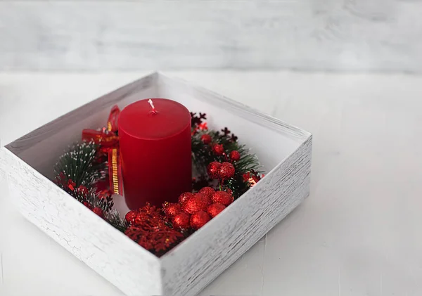 Leuchtend Rote Kerze Einer Weißen Geschenkbox Umwickelt Mit Einem Weihnachtskranz — Stockfoto