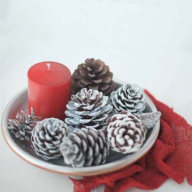 bir daire bir kaşık çay bir fincan yeşil çam ağacı çam kırmızı mum parlak ışıklar ve peçete üzerinde beyaz bir adam ile Noel Kış dekorasyonu ile