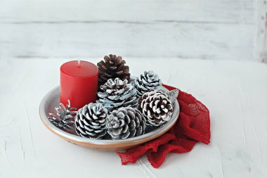 Kış Noel natürmort kırmızı mum gümüş koniler ve peçete kumaş üzerine beyaz adam