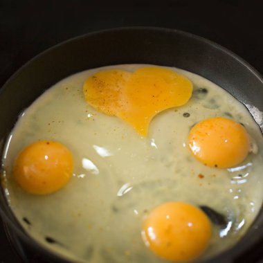 baharat ve maydanoz ile bir kalp şeklinde bir tavada kızarmış yumurta
