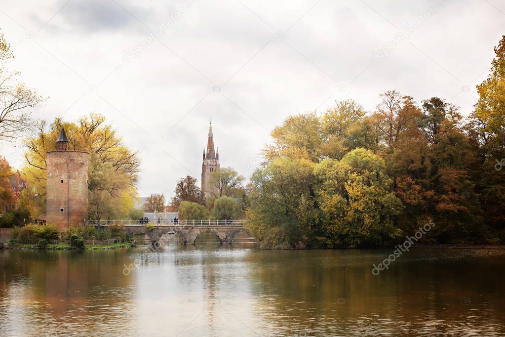autumn park Minnewater and Poertoren Tower in Bruges