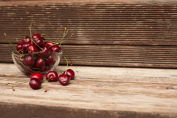 Tahta arka planda bir kasede kiraz