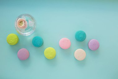 ranunculus ile mavi dokusal arka plan üzerinde renkli macaroons