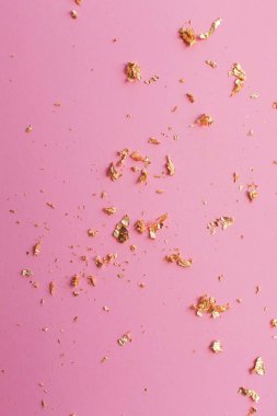 pembe parlak arka plan üzerinde altın parçaları
