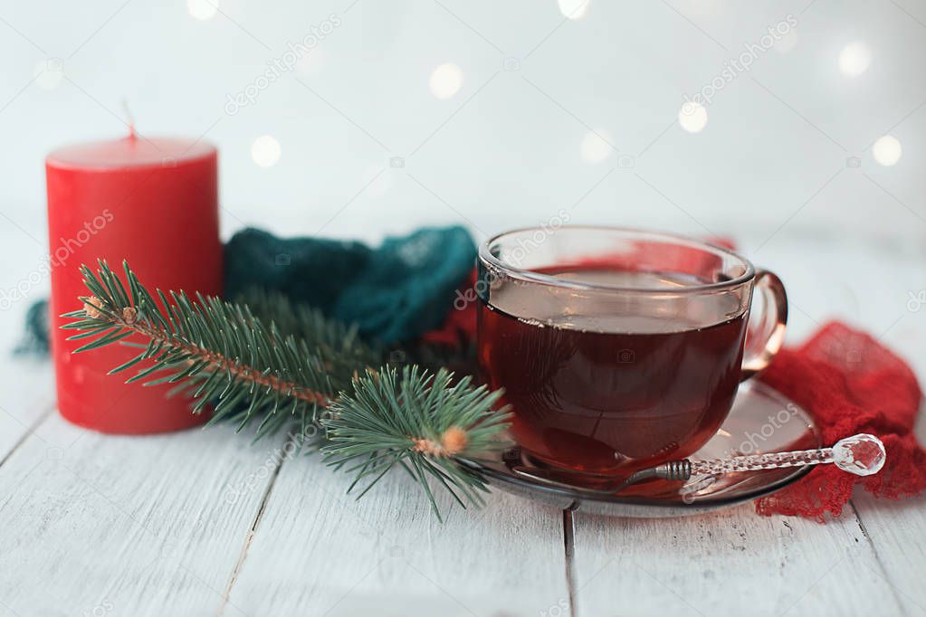cup of tea with Christmas decoration with pine candle lights and