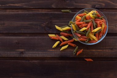 koyu ahşap arka plan üzerinde cam bir kapta sebze makarna