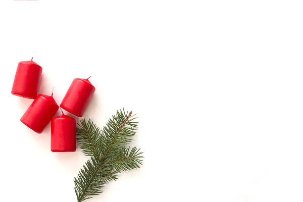 Kerzen und weihnachtlicher grüner Tannenzweig auf hellem Hintergrund. — Stockfoto