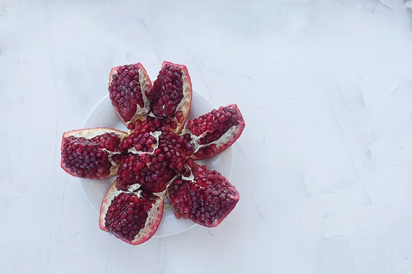 Fruta de romã fatiada em um fundo de textura branca . — Fotografia de Stock