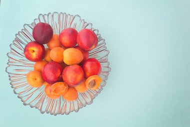 Arka planda cam bir vazoda kayısılar. Model ve projeniz için minimalist bir konsept. Düzen, düzlük, kopyalama alanı, üst görünüm. Seçici odak