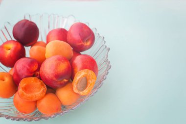 Arka planda cam bir vazoda kayısılar. Seçici odaklanma. Model ve projenin konsepti. Düzen, kopyalama alanı.